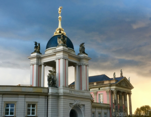 Das Fortunaportal des Potsdamer Stadtschloss strahlend vor einem düsteren Himmel